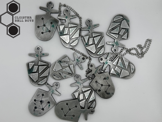 Collection of "McGann Keys", silver pendants on a white background with 'Cloister Bell Boys' branding. Some are attached to chains and some are not.