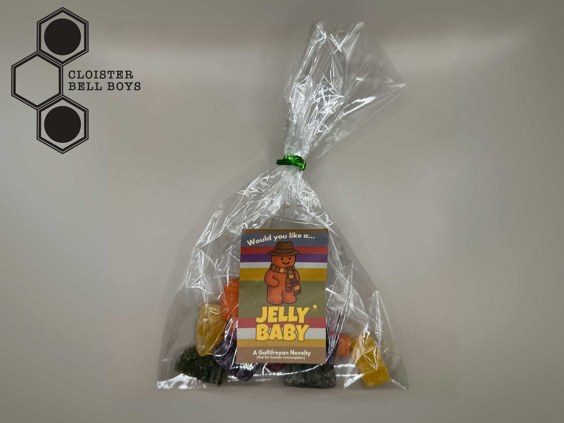 Clear plastic bag with resin jelly baby candy and a colorful label on a light grey background.